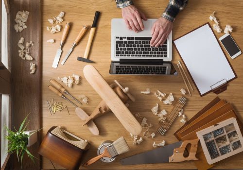 working at a table with a laptop and tools