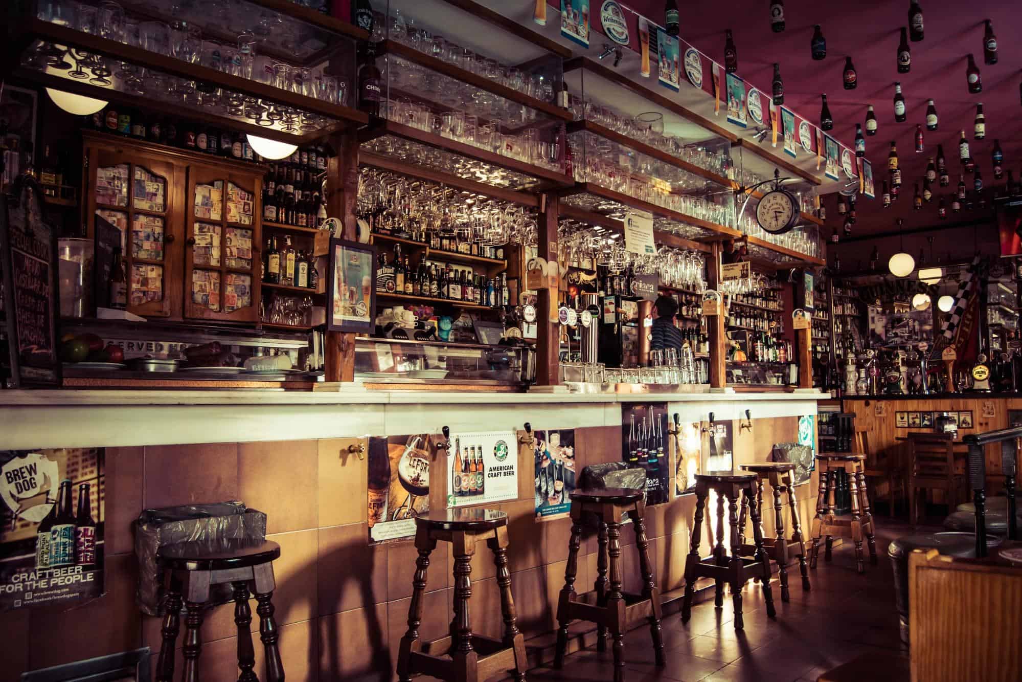 barstools and shelves with liquor bottles in an empty bar