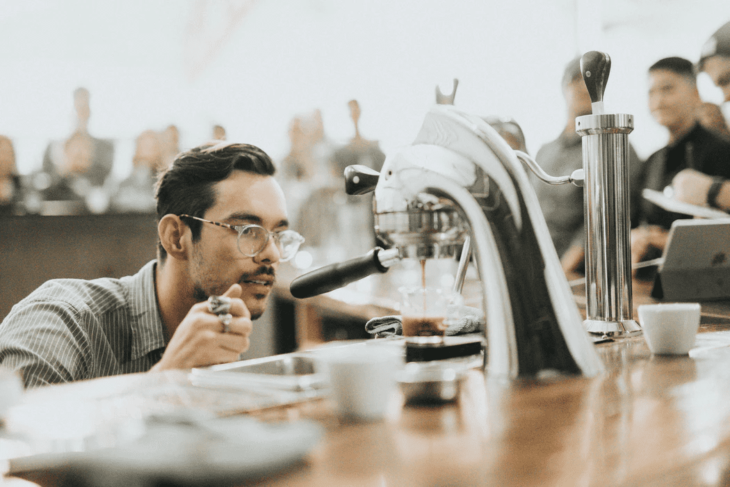 barista watching espresso pour into a cup