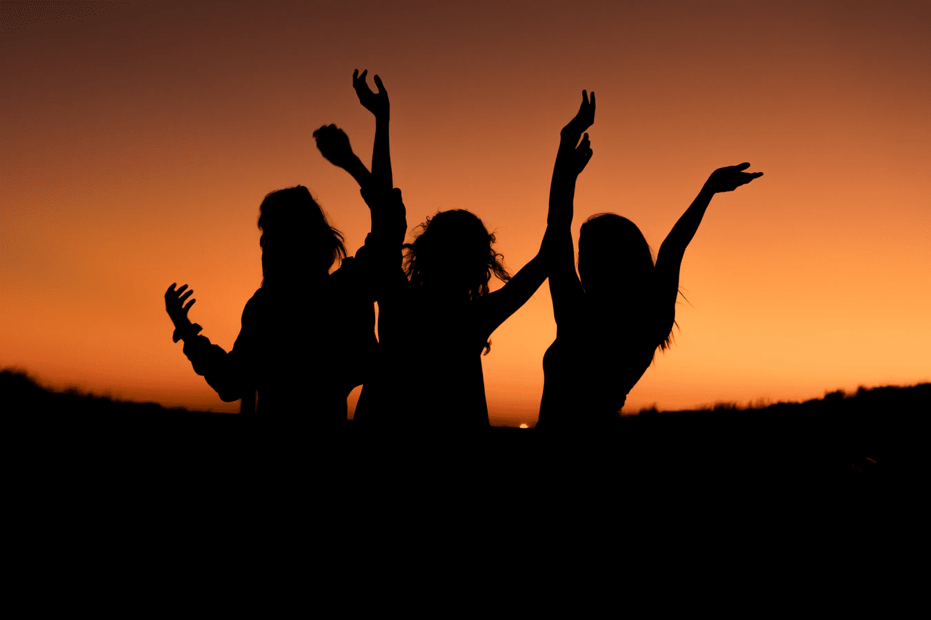 Silhouette of three people at sunset 