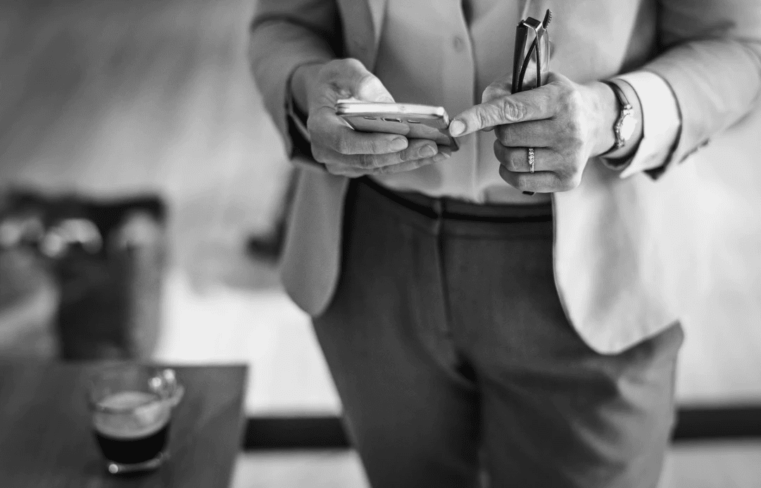 Business owner looking at payroll reports on his mobile device