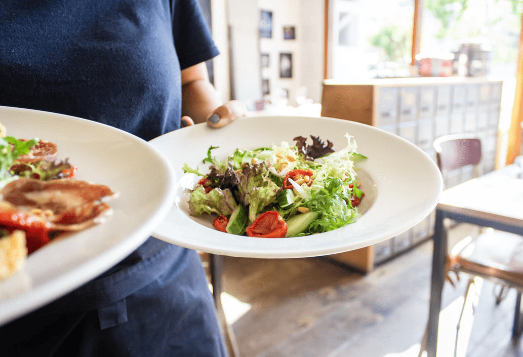 Waiter carrying food from back of house (BOH) to front of House (FOH)