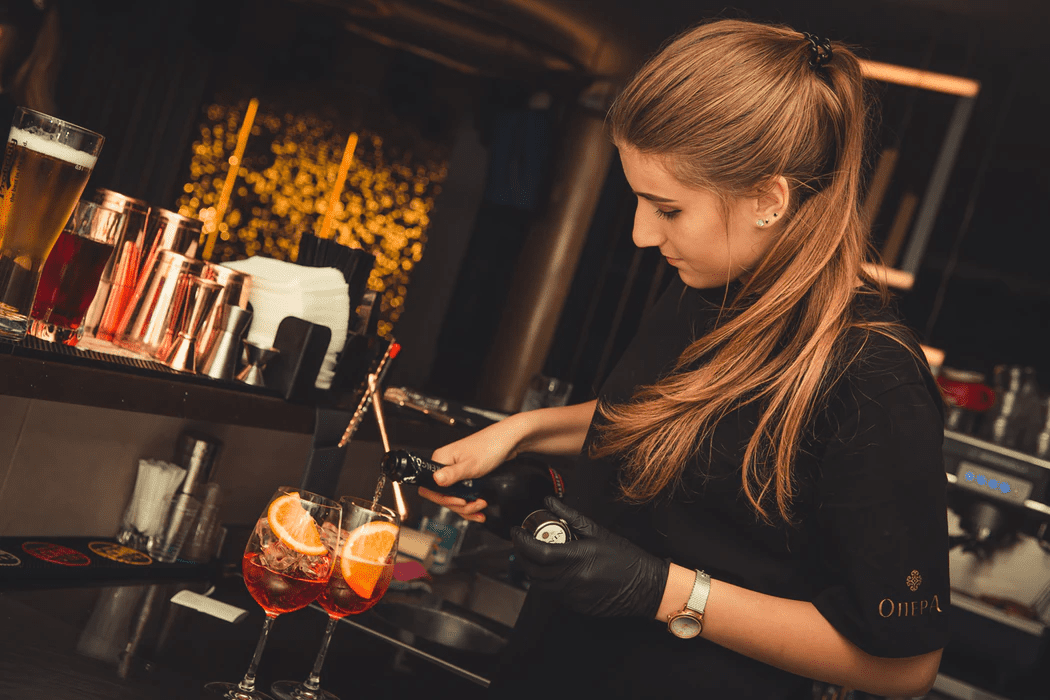 Bartender a servir bebidas em frente de casa (FOH)/Back of house (BOH)