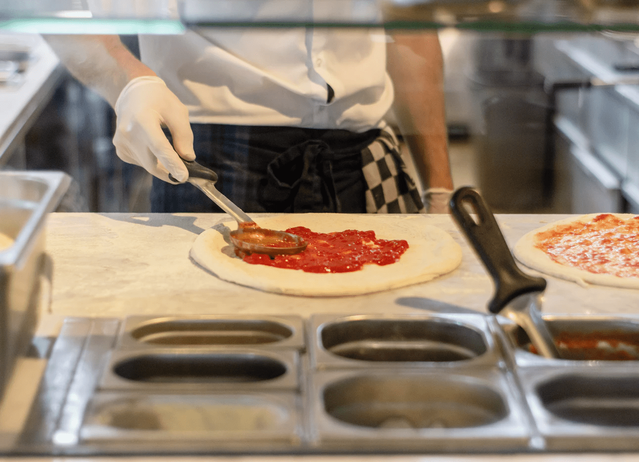 Chef in a restaurant preparing a pizza