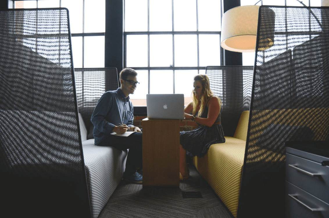 Two employees working together on a laptop