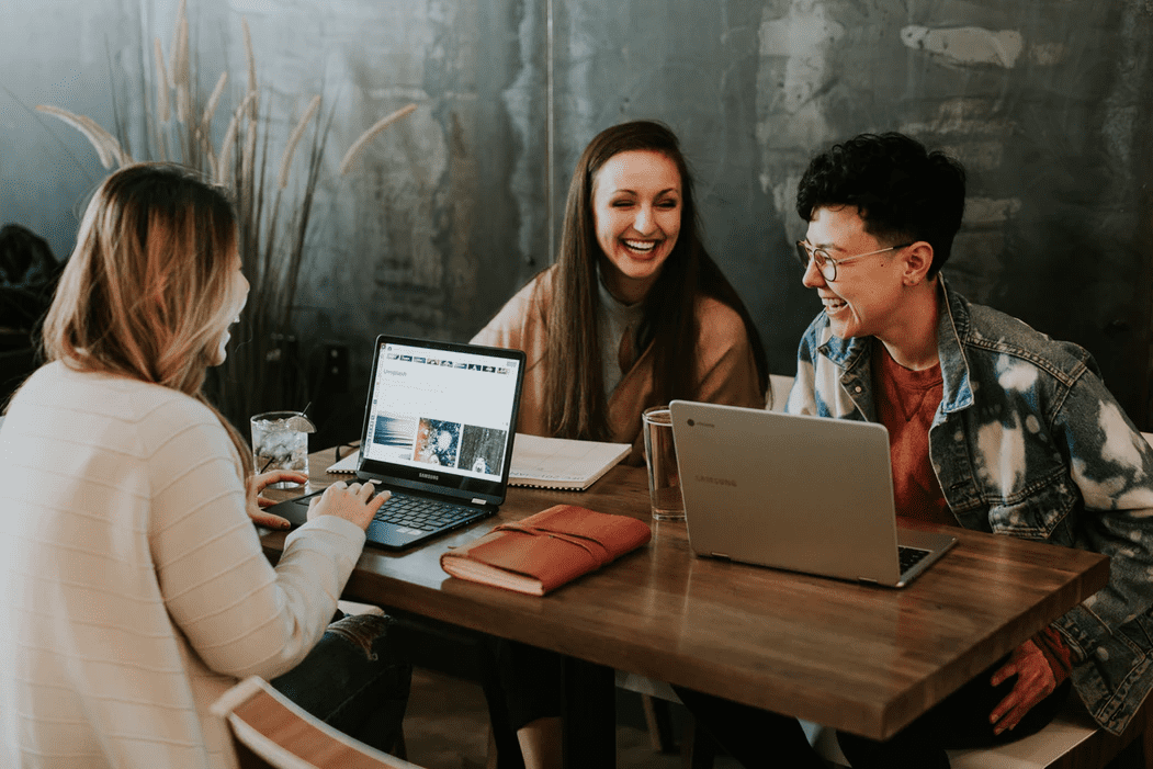 Coworkers laughing in a meeting about employee burnout