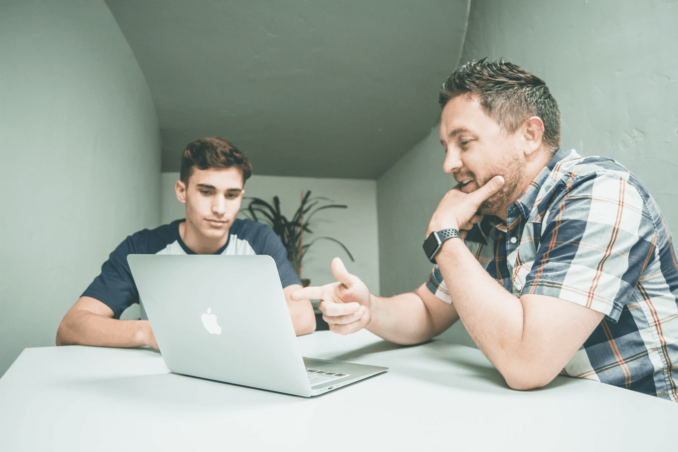 Manager and employee looking at laptop in small office