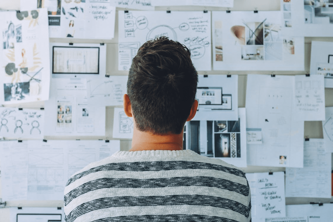 Man looking at charts on a wall for his restaurant business plan