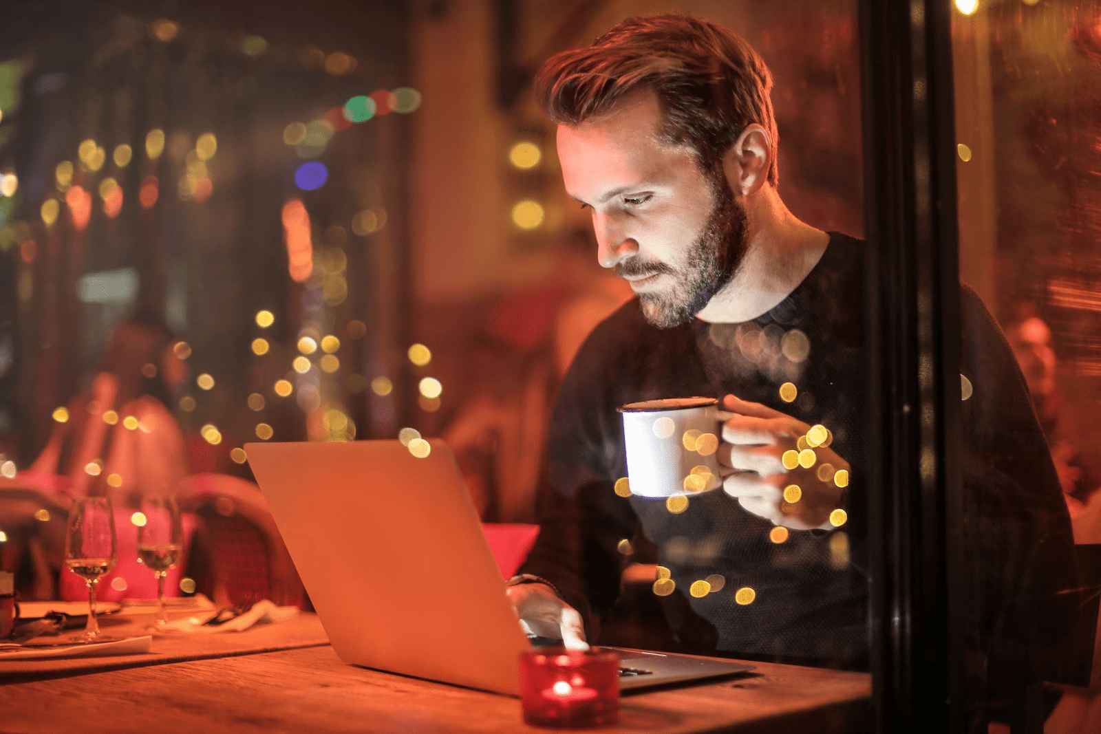 Man remote working at a restaurant at night