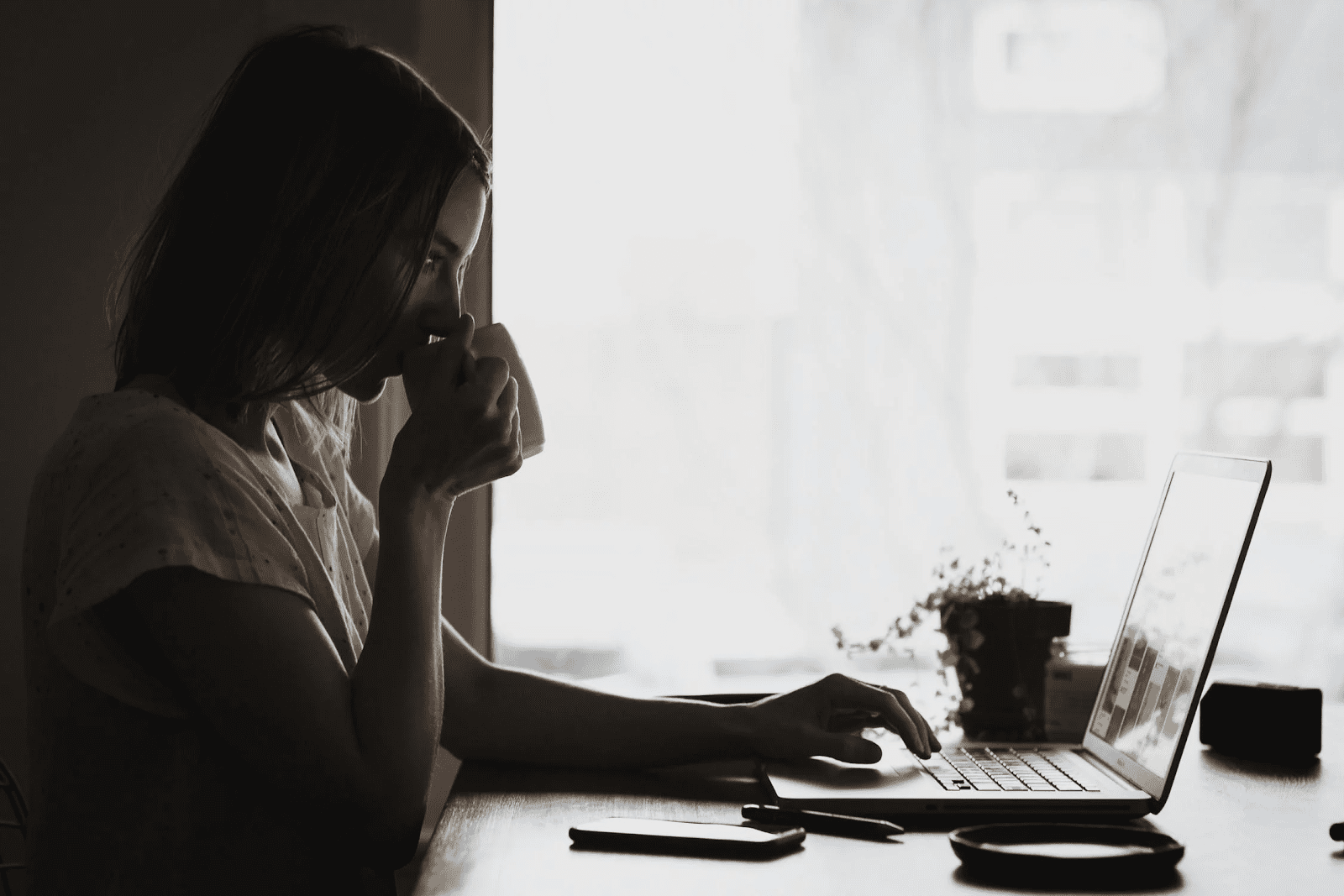 woman working on her laptop and drinking coffee