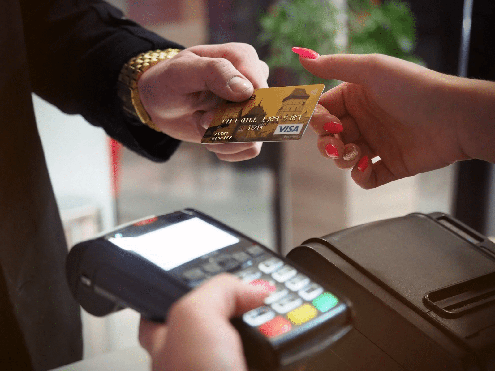 man paying store clerk with a credit card