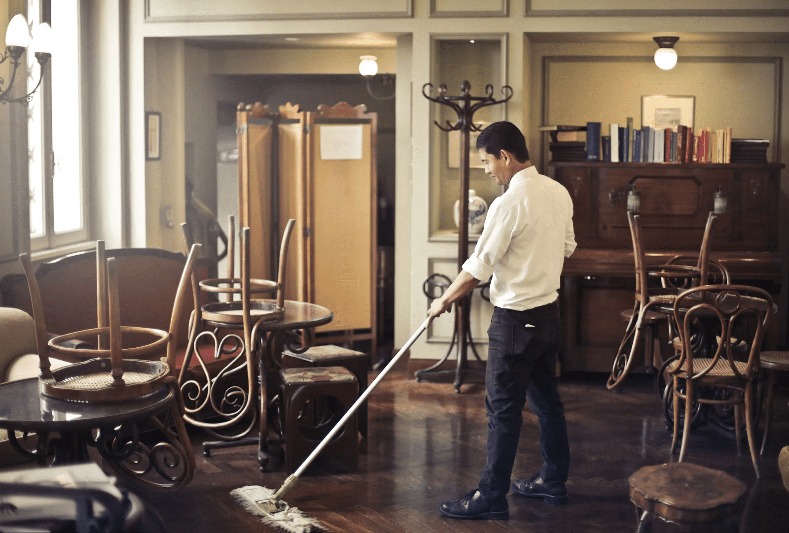 Man practicing how to clean a restaurant with a mop