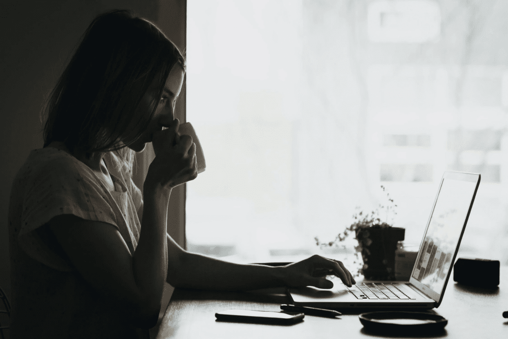 Woman setting up self-scheduling on computer while drink coffee