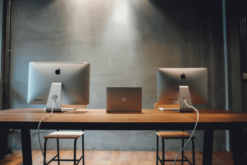 Two computers and a laptop on a desk
