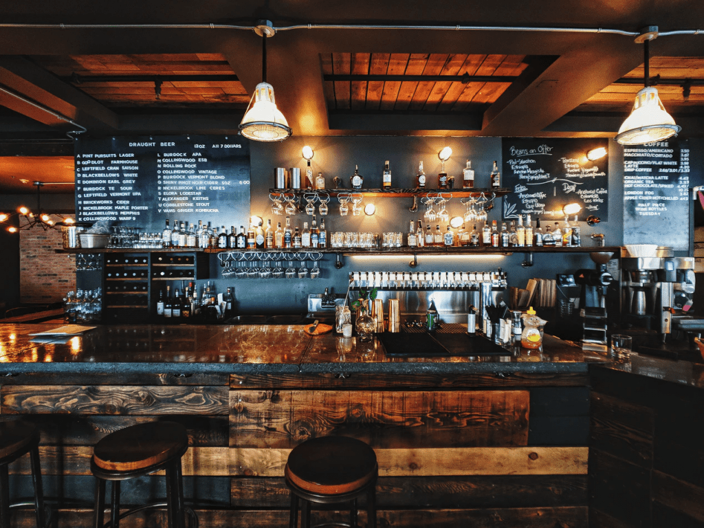 Inside a rustic bar with wood bar top and bar stools