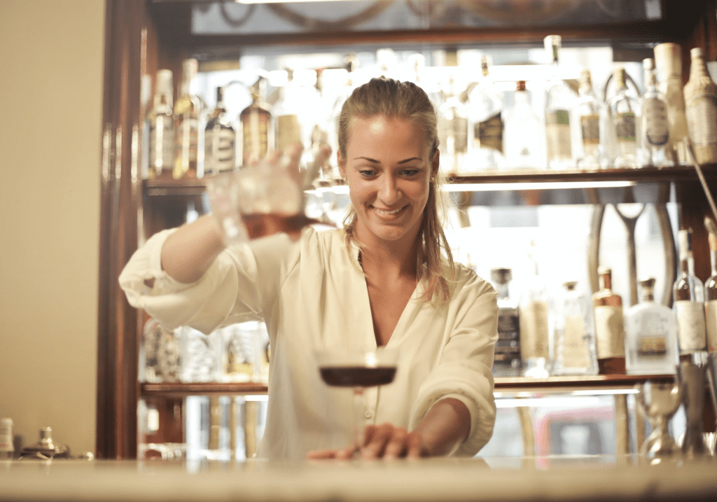 high-performing employee pouring a drink for bar customer