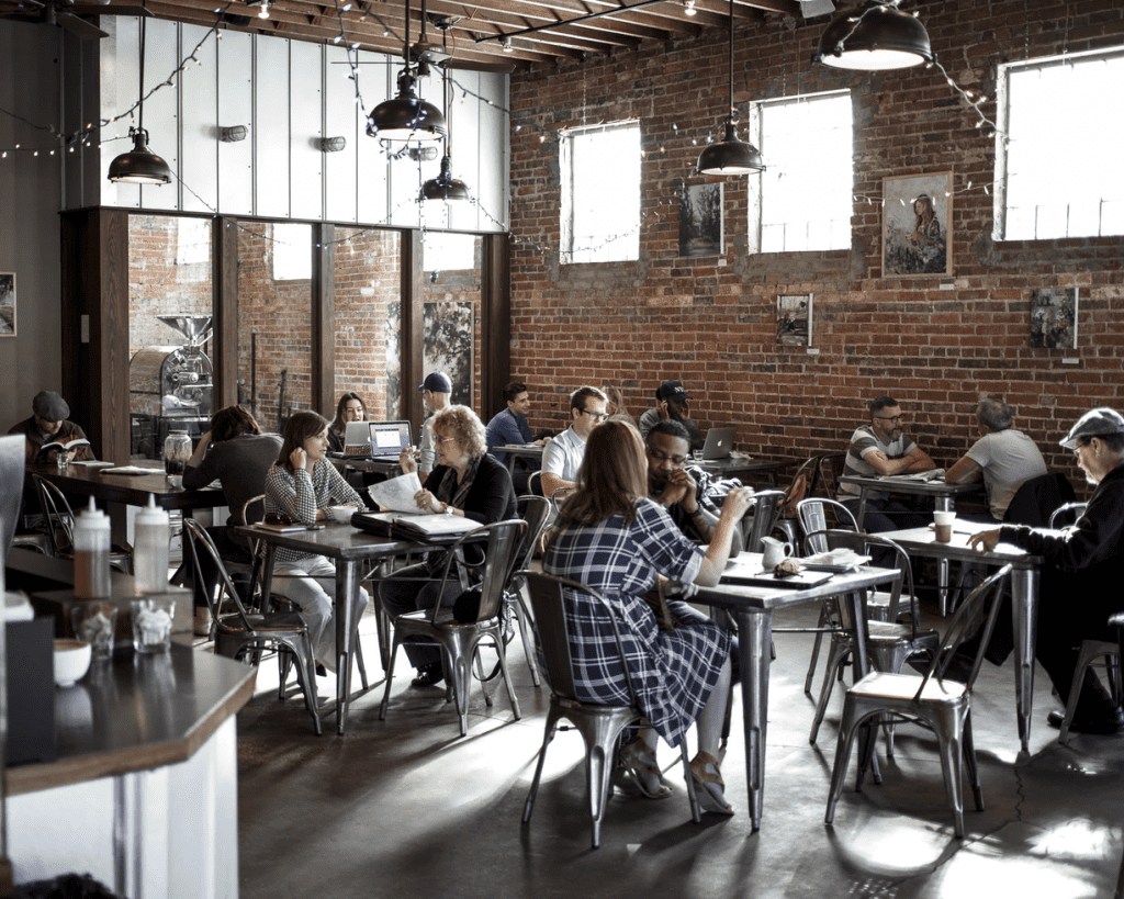 Customers enjoying breakfast in a restaurant with brick walls  