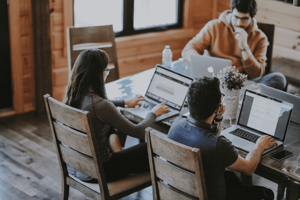 Three people working on laptops in co-working space