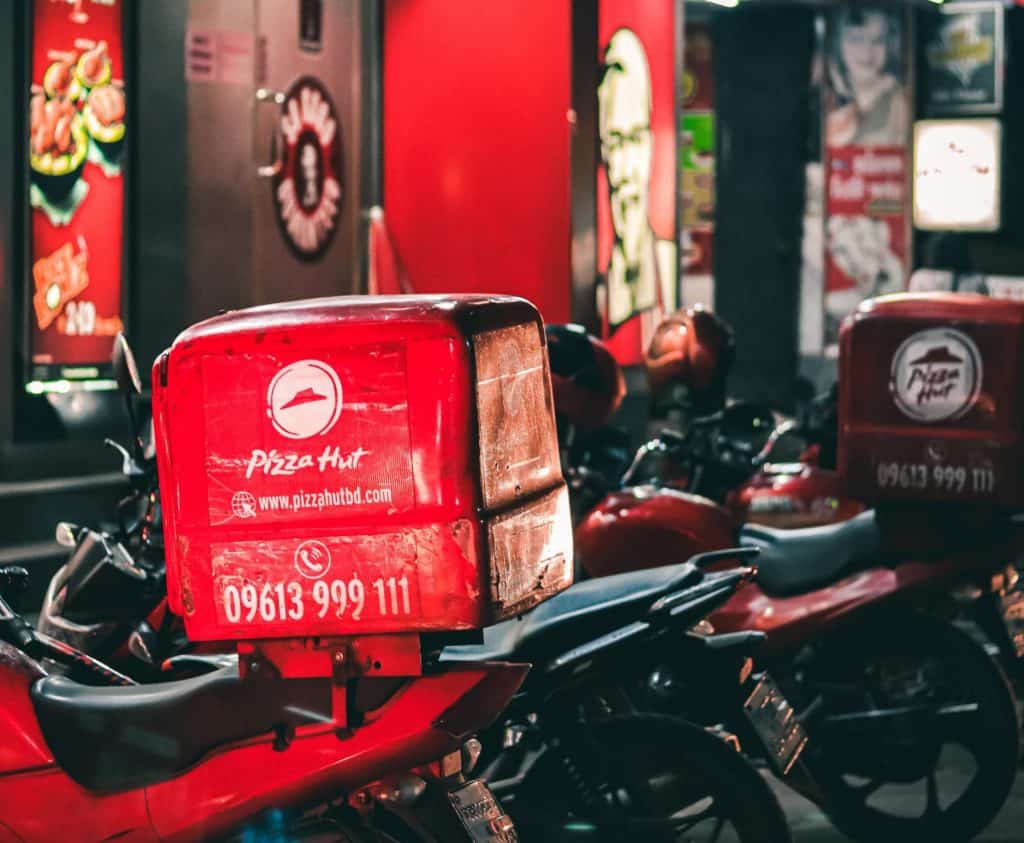 Motorcycle with a pizza hut heat box for delivery services to help with the gig economy