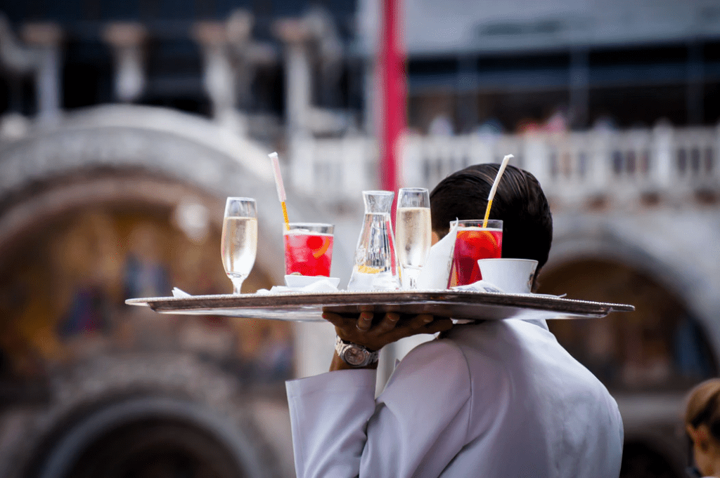 Waiter carrying drinks to a table