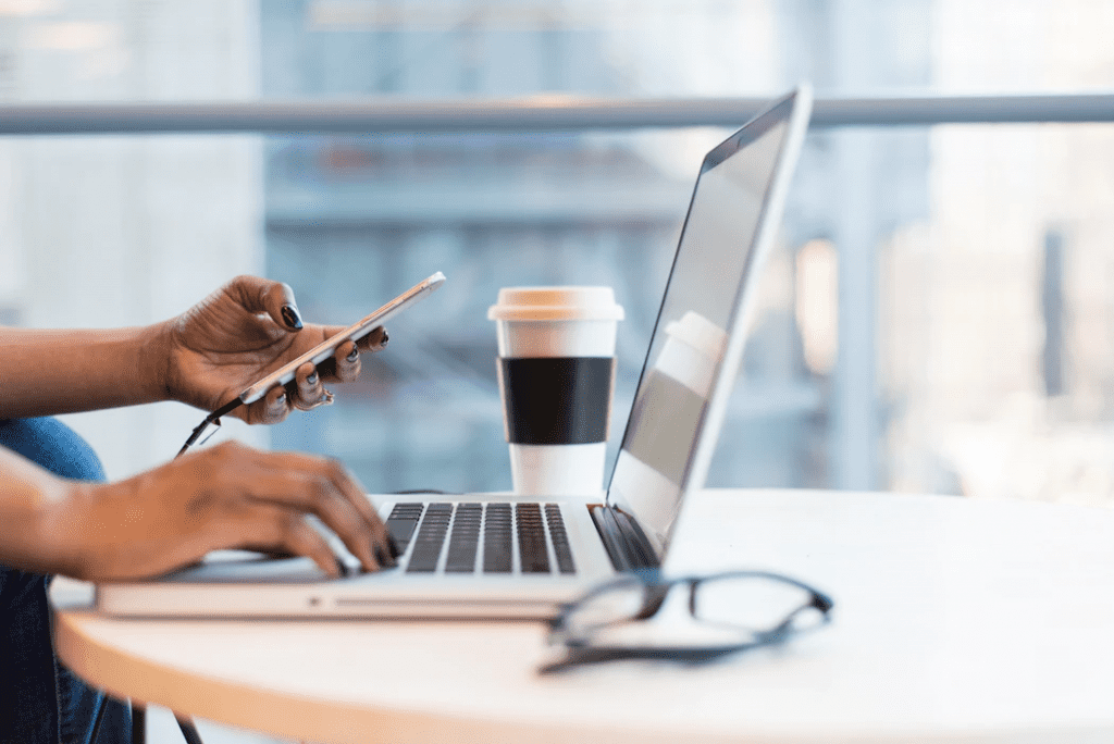 Woman working on her cell phone and laptop during an on call schedule