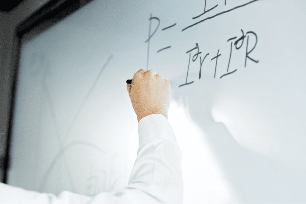 Man writing on a formula on a whiteboard