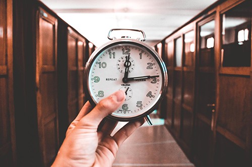 Person holding an alarm clock