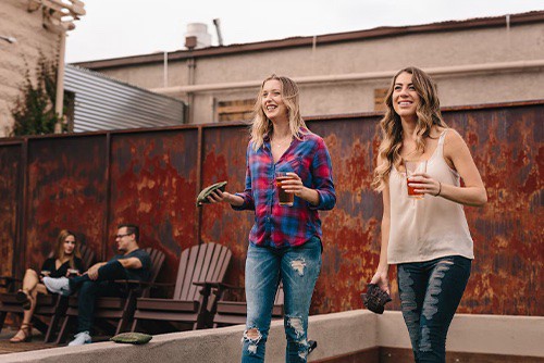 Two girls playing corn hole