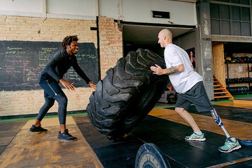 Two men flipping a giant tire
