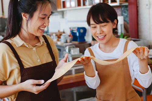 two people making pasta