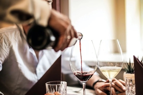 Person pouring a glass of wine