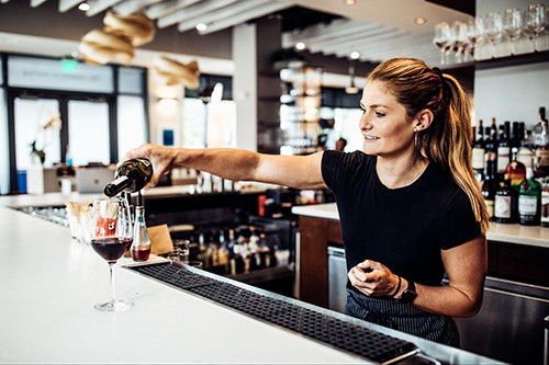 Woman pouring wine at a bar