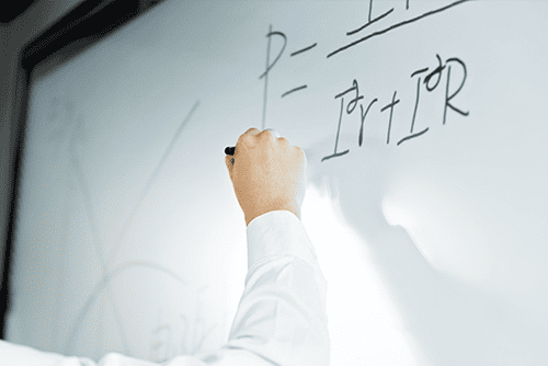 Man writing on a formula on a whiteboard
